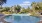 a swimming pool with trees and a building in the background