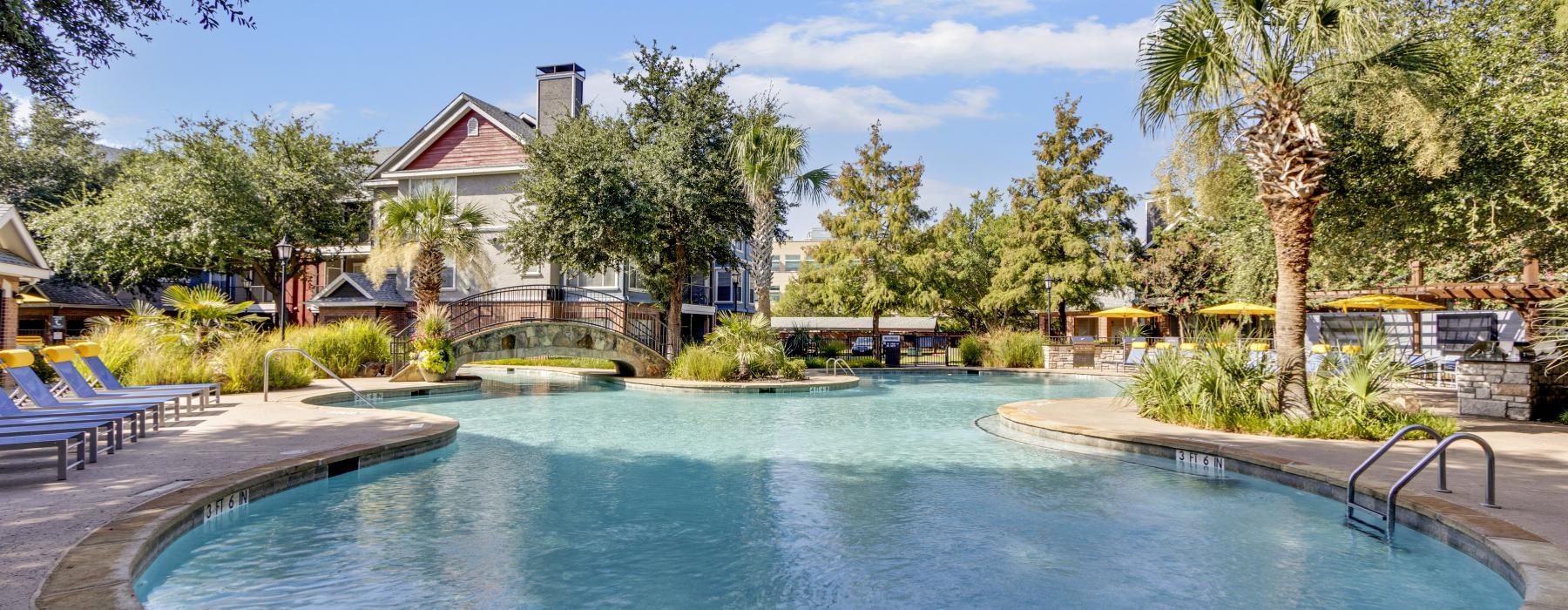 a swimming pool with trees and a building in the background